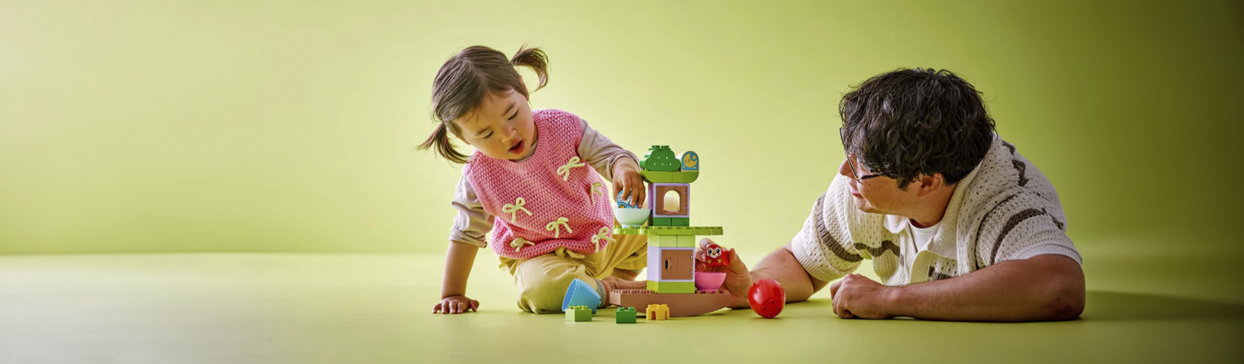 Padre e hijo jugando con LEGO en casa.
